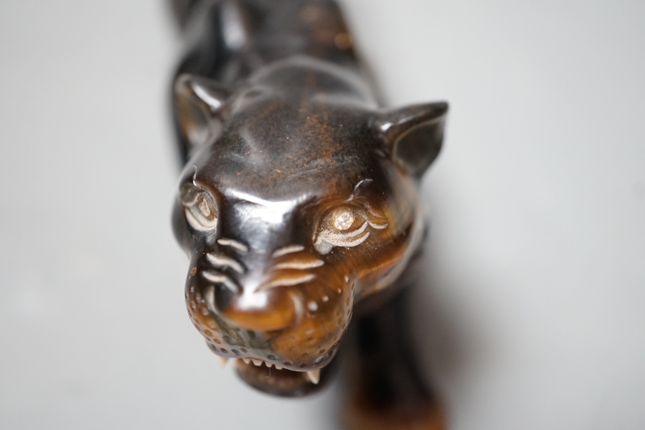 A carved tigers eye model of a tiger with paste set eyes. Makers mark ‘WG’ to paw underside. Numbered 974. 19cm long